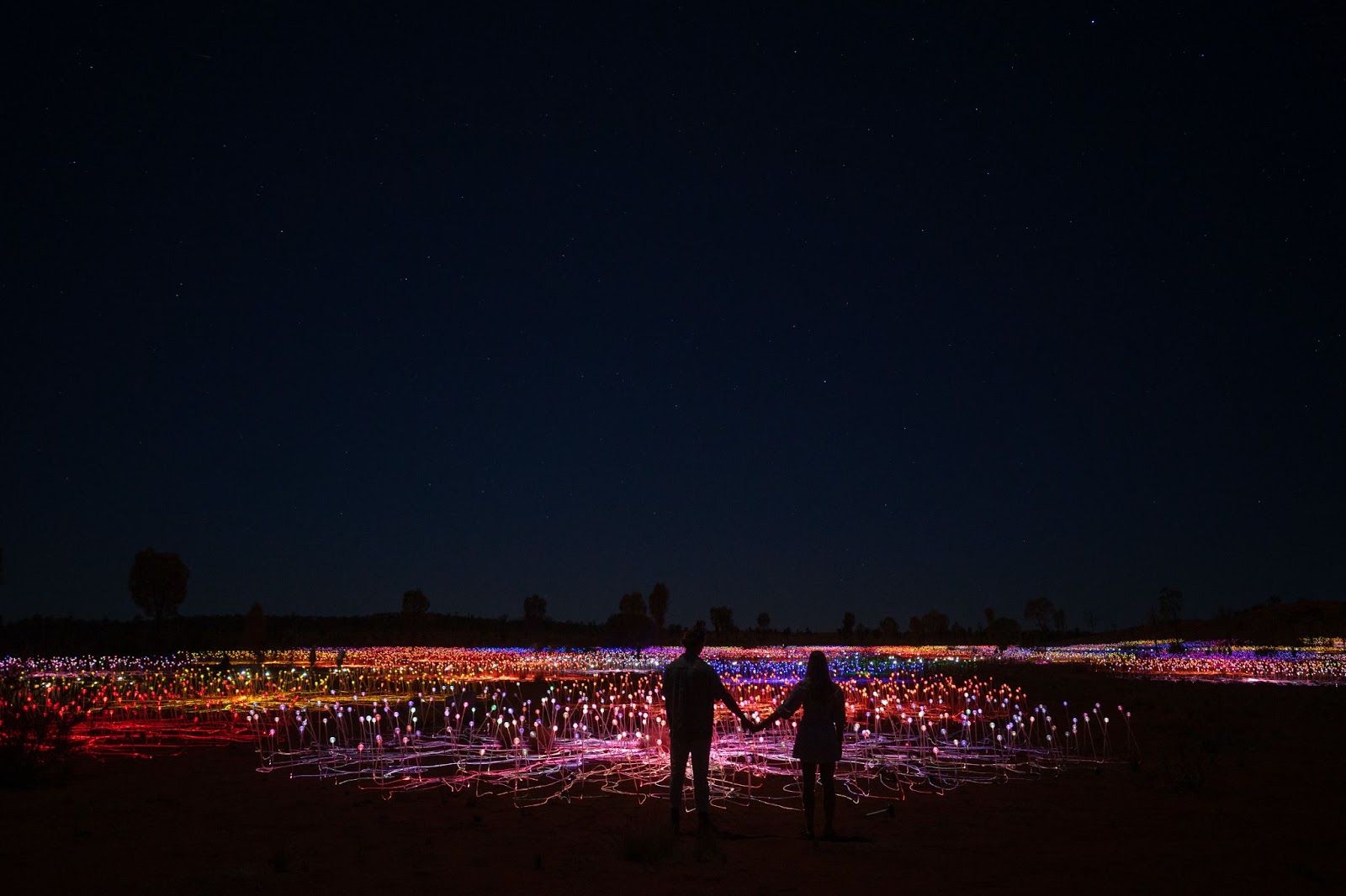 Couple having a romantic walk at the Field of Light in Uluru
