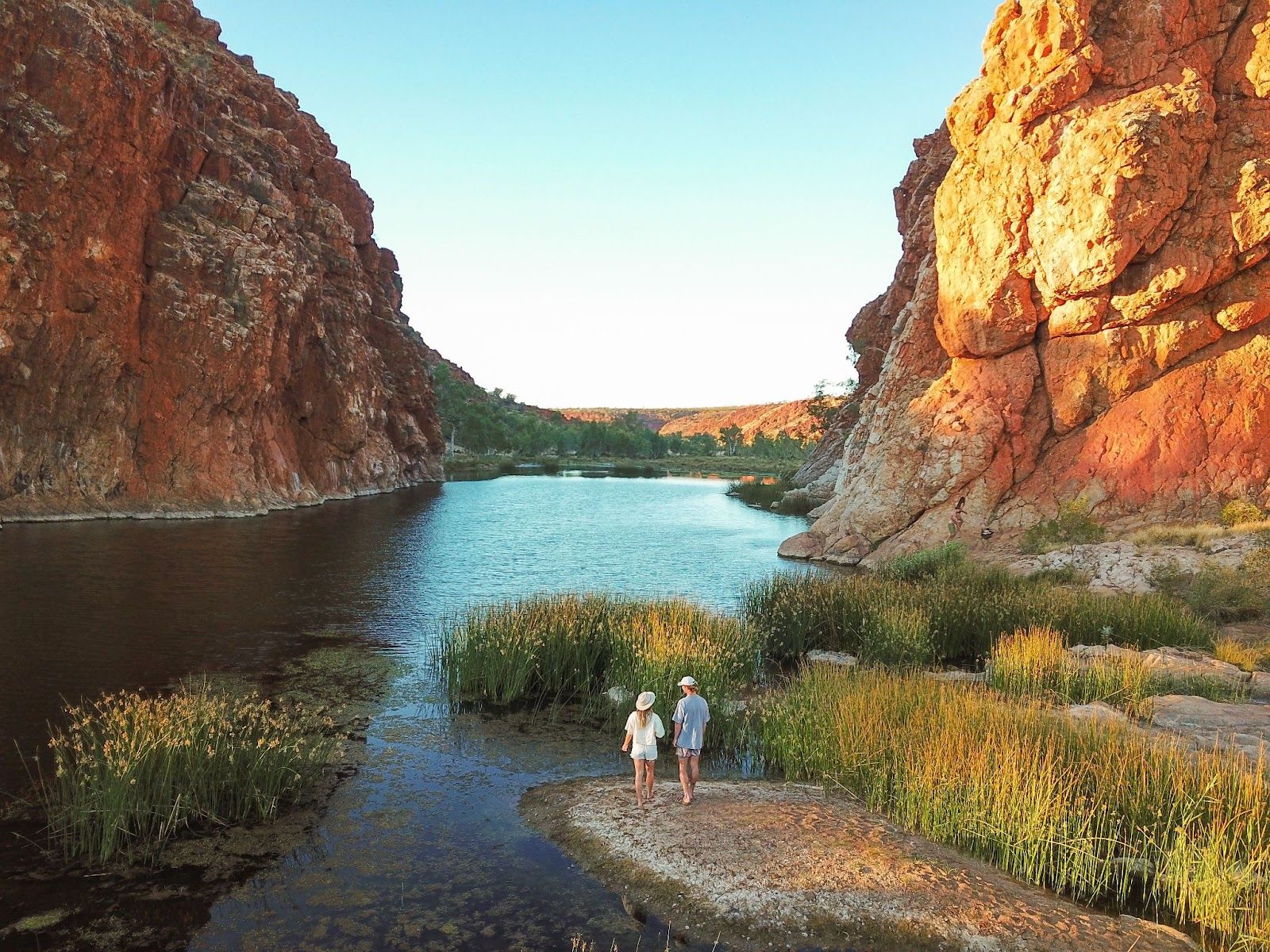 Couple enjoying scenic walk by the water in the Red Centre